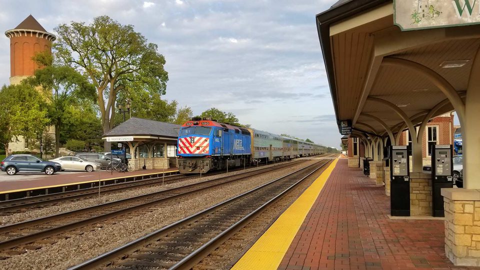 Metra train arriving suburb station.