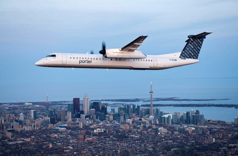 Porter Airlines aircraft flying with the Toronto skyline in the background.