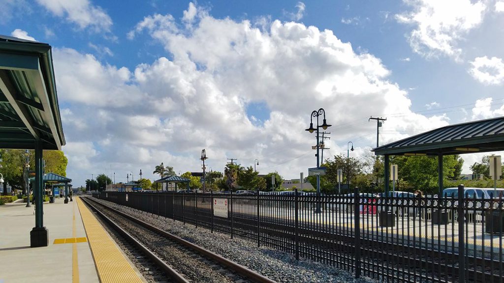 Train station platform with blue skies and white clouds in the background.