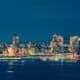Colorful Seattle skyline reflects on the water at night.